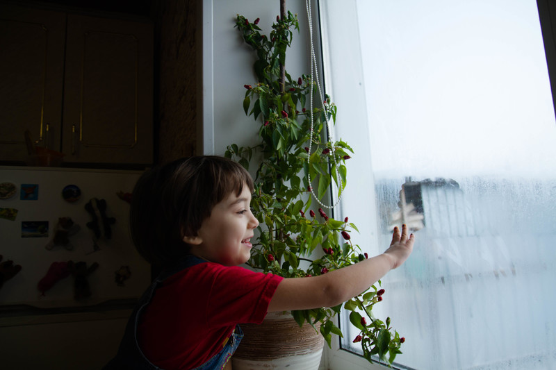 Ребёнок смотрит в запотевшее окно